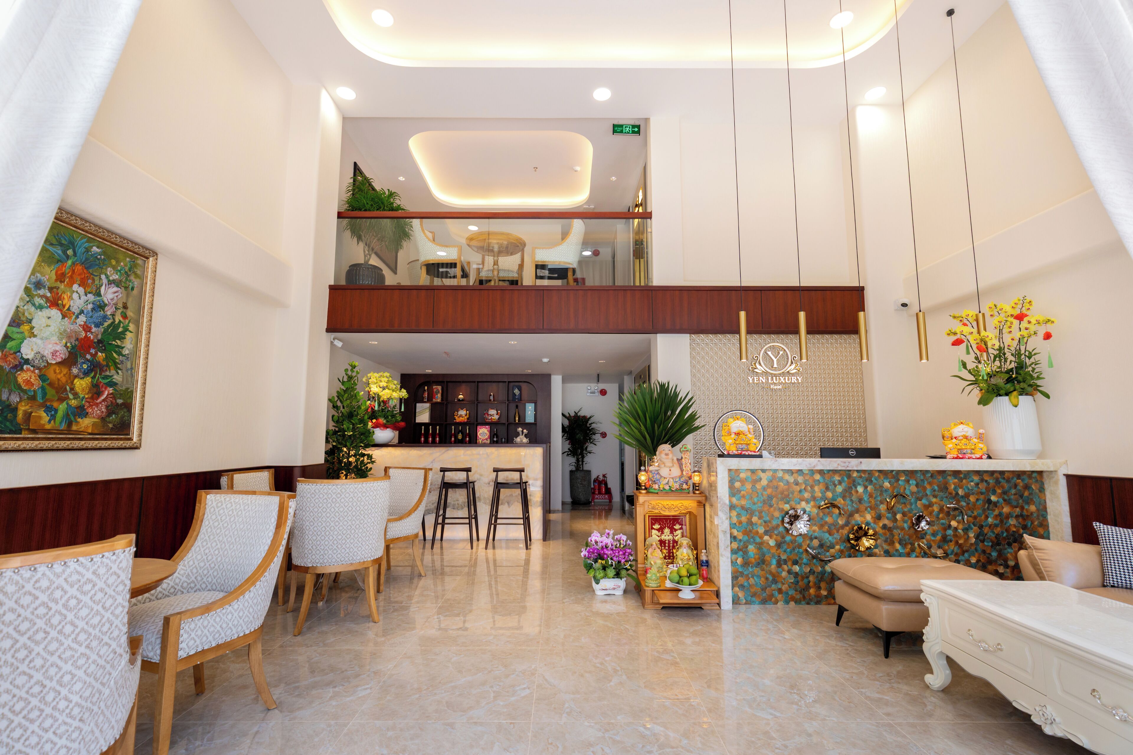 A hotel lobby with a reception desk, seating area, and a decorative altar.