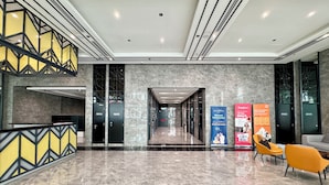 A modern lobby with a marble floor, a reception desk, and a staircase. - Alinea Suites (Shah Alam)