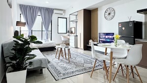 A modern hotel room with a bed, a desk, a dining area, and a kitchen. - Alinea Suites (Shah Alam)