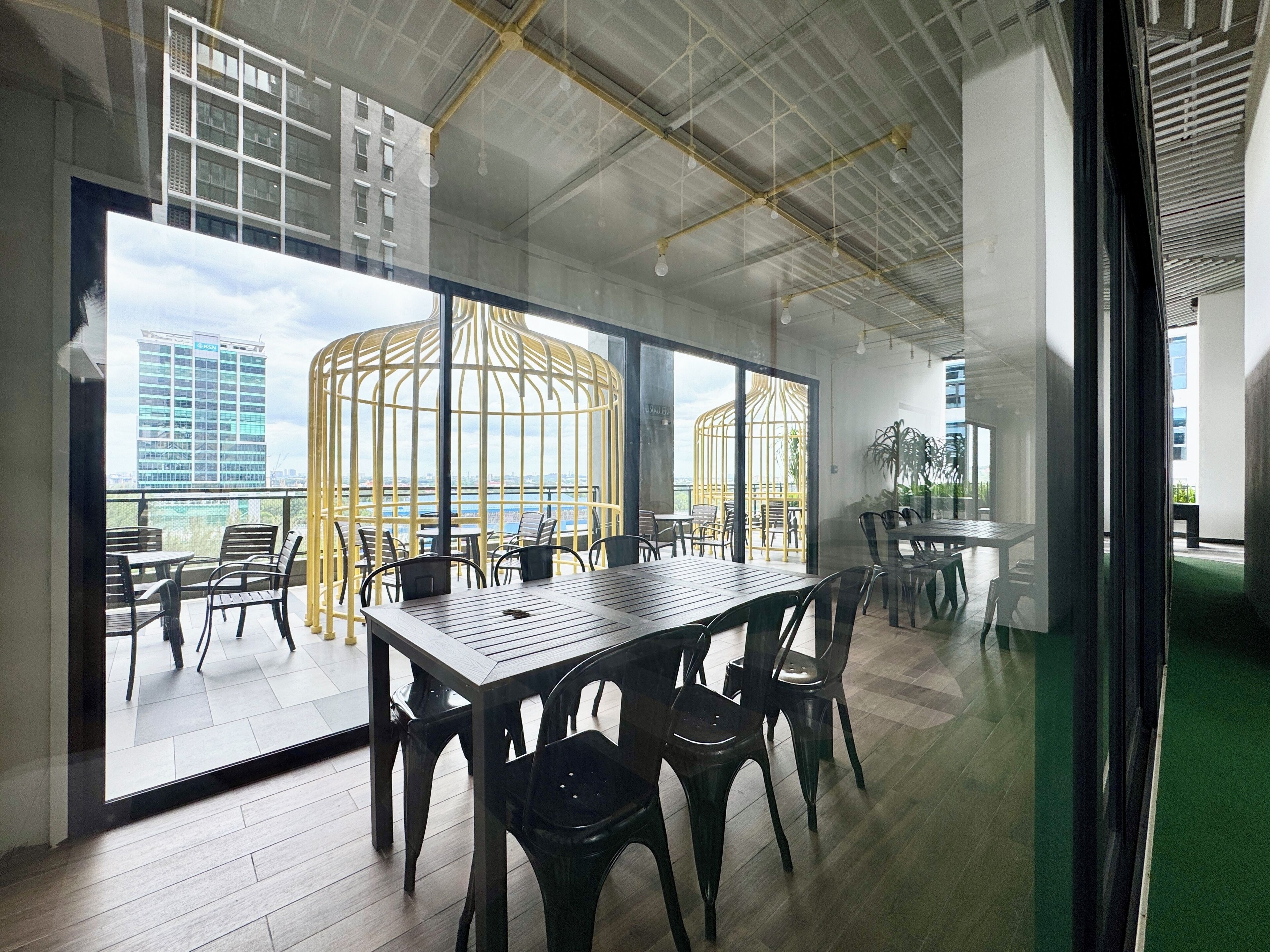A modern meeting room with glass walls, a wooden table, and chairs.