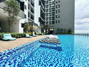 Een buitenzwembad en ligstoelen