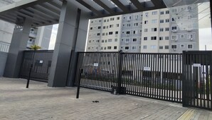 A modern building with a covered walkway and a black metal fence. - Apartment 600 meters from the beach (Ponta de Campina Cabedelo)