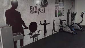 A gym wall with silhouettes of people exercising, a dumbbell, and motivational text. - Apartment 600 meters from the beach (Ponta de Campina Cabedelo)