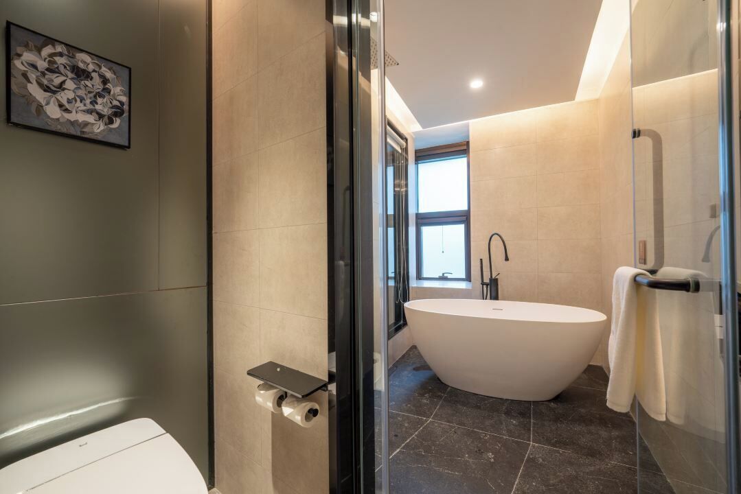Un bagno moderno con una vasca da bagno indipendente, un water e un box doccia in vetro.