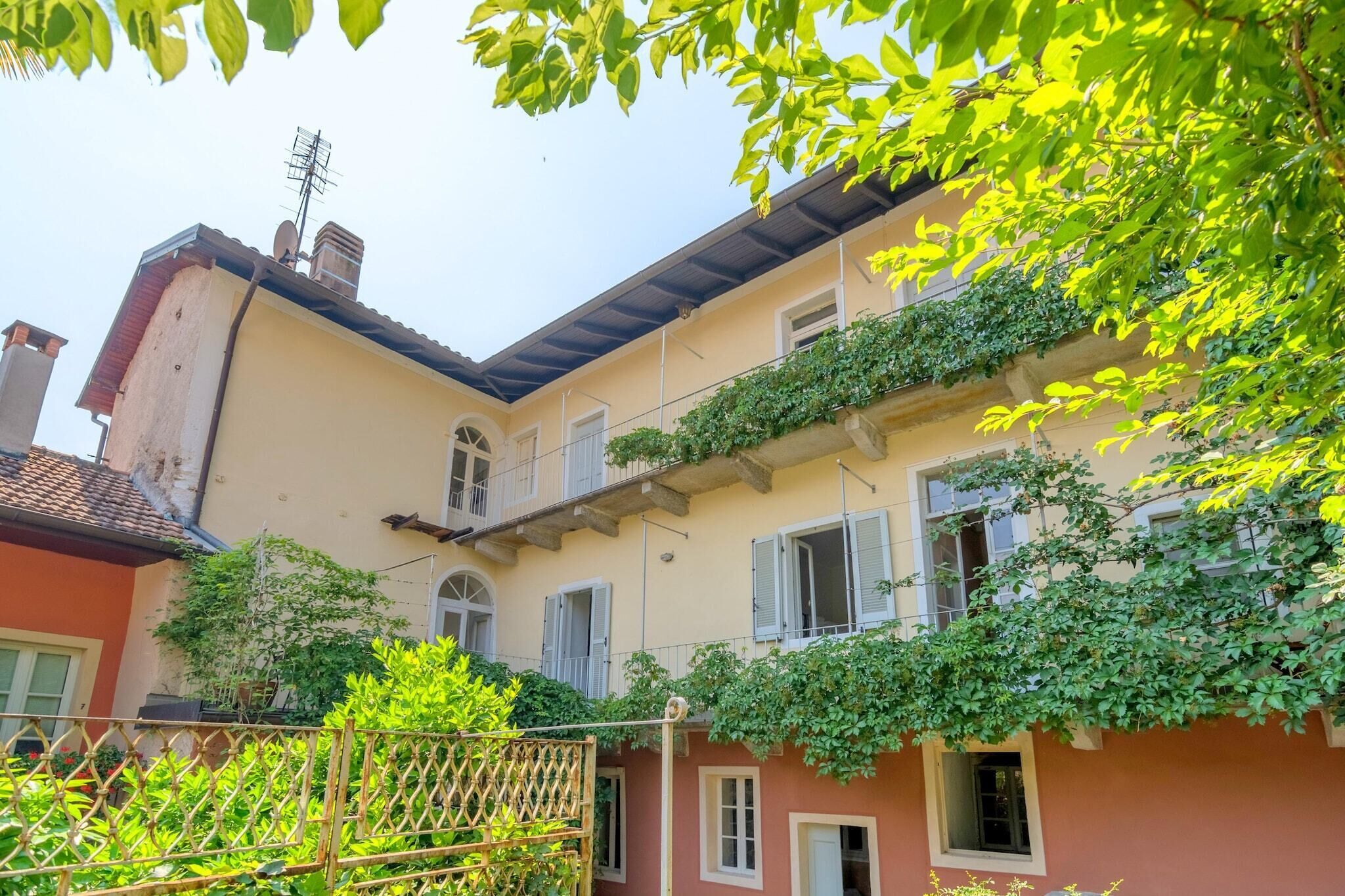 Ein mehrstöckiges Gebäude mit Balkonen, einer sichtbaren Antenne und üppiger Bepflanzung.