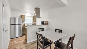 Una cocina compacta con refrigerador empotrado, una isla central con asientos y una campana extractora moderna.