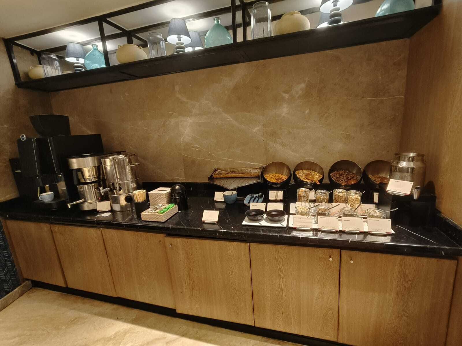 A coffee station with multiple coffee makers, a tea station, and various food items.