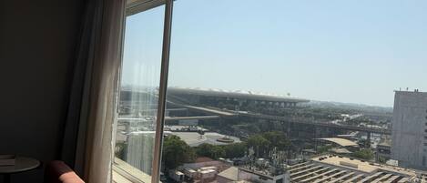 A room with a large window overlooking an airport and a cityscape.