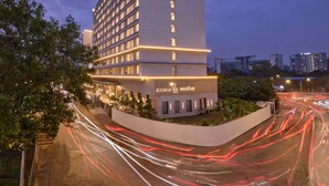 A modern hotel building with a prominent logo, multiple floors, and a well-lit facade.