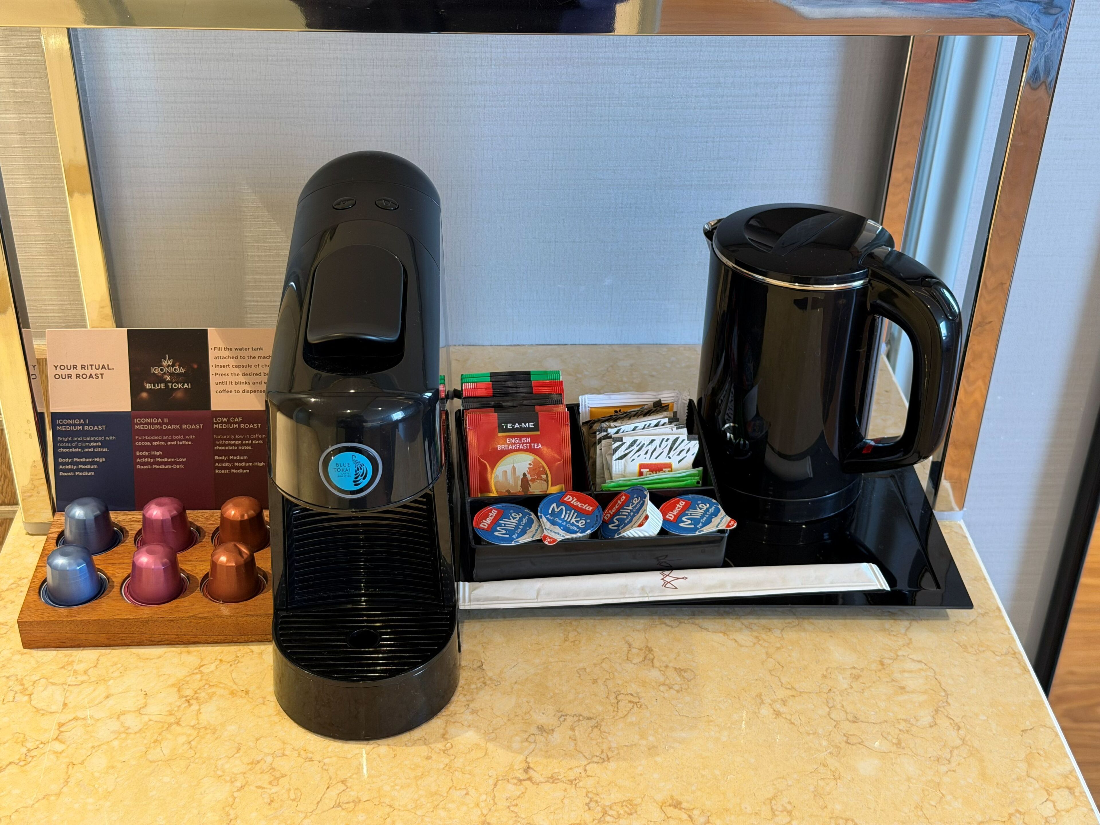 A coffee maker, a tea dispenser, and a selection of tea bags on a countertop.