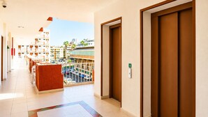 A hotel corridor with a view of the city, a pool area, and a door marked with the number 4.