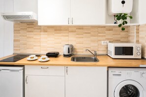 A modern kitchen with a dishwasher, washing machine, microwave, and a sink. - Modern Studio with Pool, Puerto de La Cruz (Puerto de la Cruz)