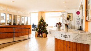 A reception area with a Christmas tree, a marble counter, and a wheelchair-accessible ramp.