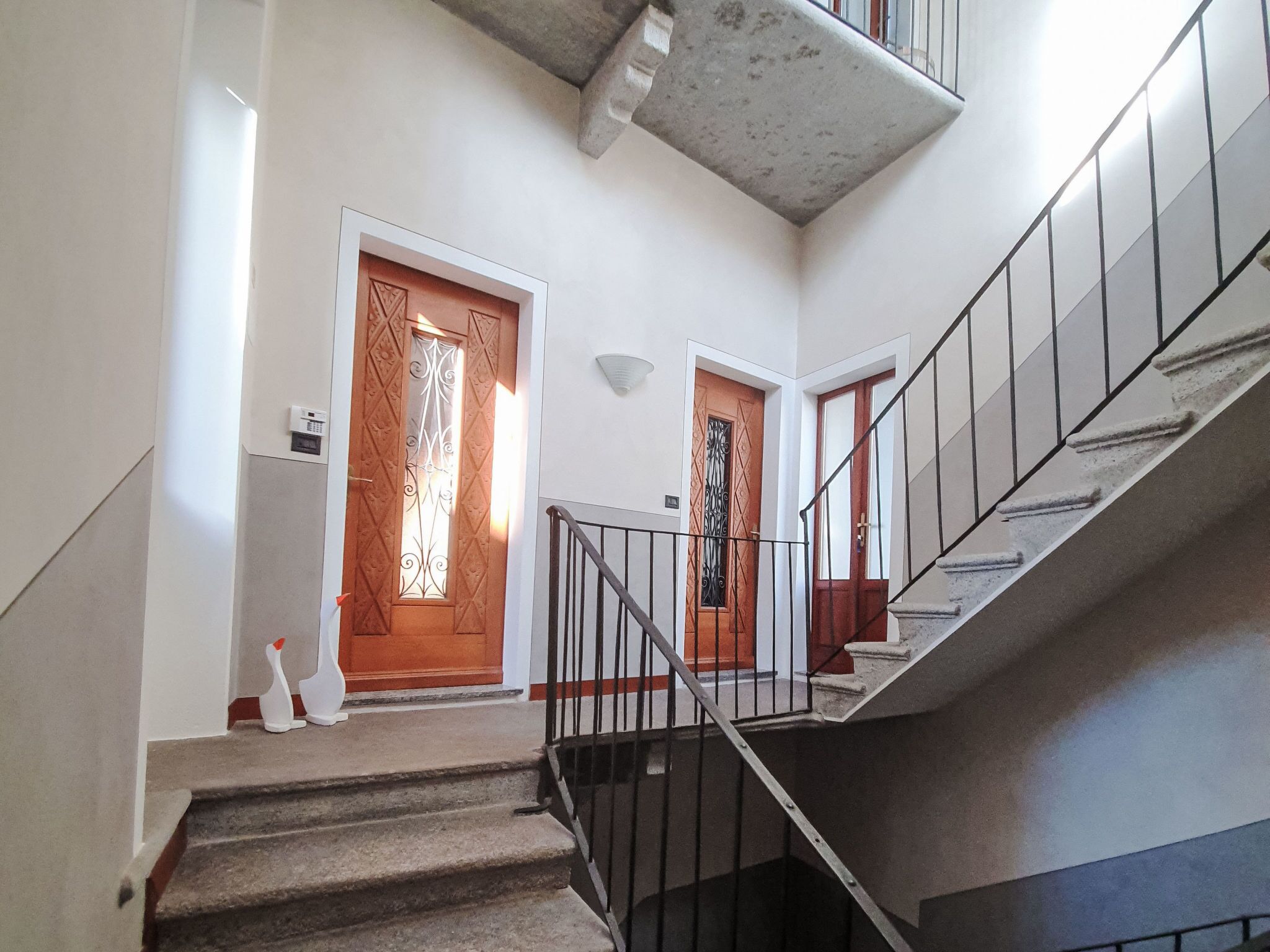 A staircase leading to a landing with two wooden doors, each with a decorative glass panel.