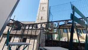 Une vue d’un bâtiment historique doté d’une haute tour et d’une clôture métallique au premier plan.