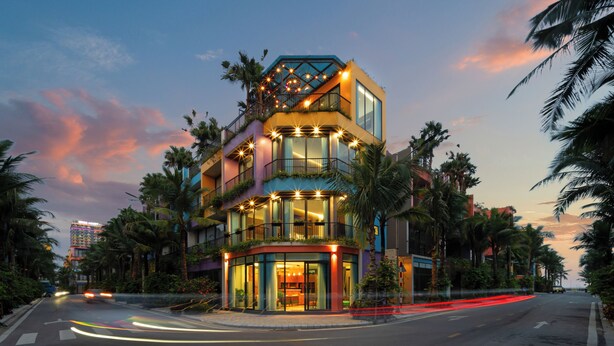 A multi-story hotel with balconies, large windows, and a central courtyard.