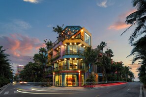 A multi-story hotel with balconies, large windows, and a central courtyard. - Khue Le Bleu Villa- Flamingo Hai Tien (Hoang Tien)