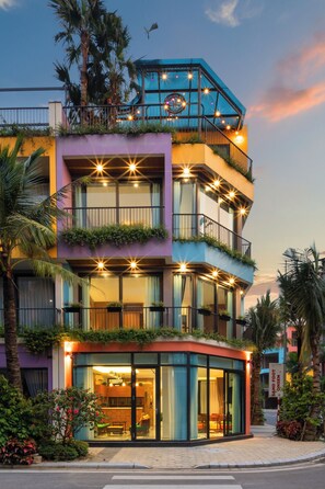 A multi-story building with balconies, large windows, and outdoor seating areas. - Khue Le Bleu Villa- Flamingo Hai Tien (Hoang Tien)