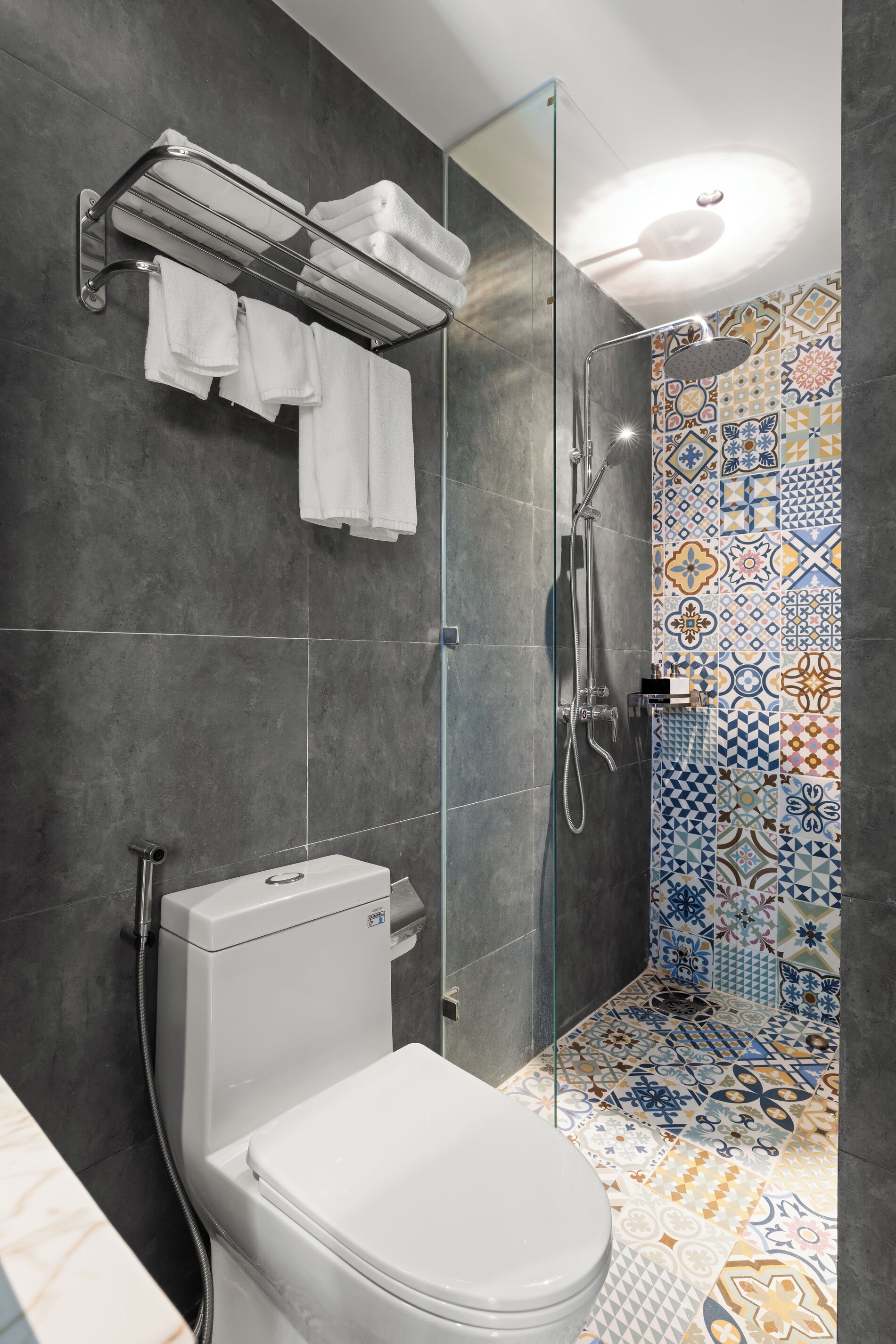 A modern bathroom with a shower, toilet, and towel rack.