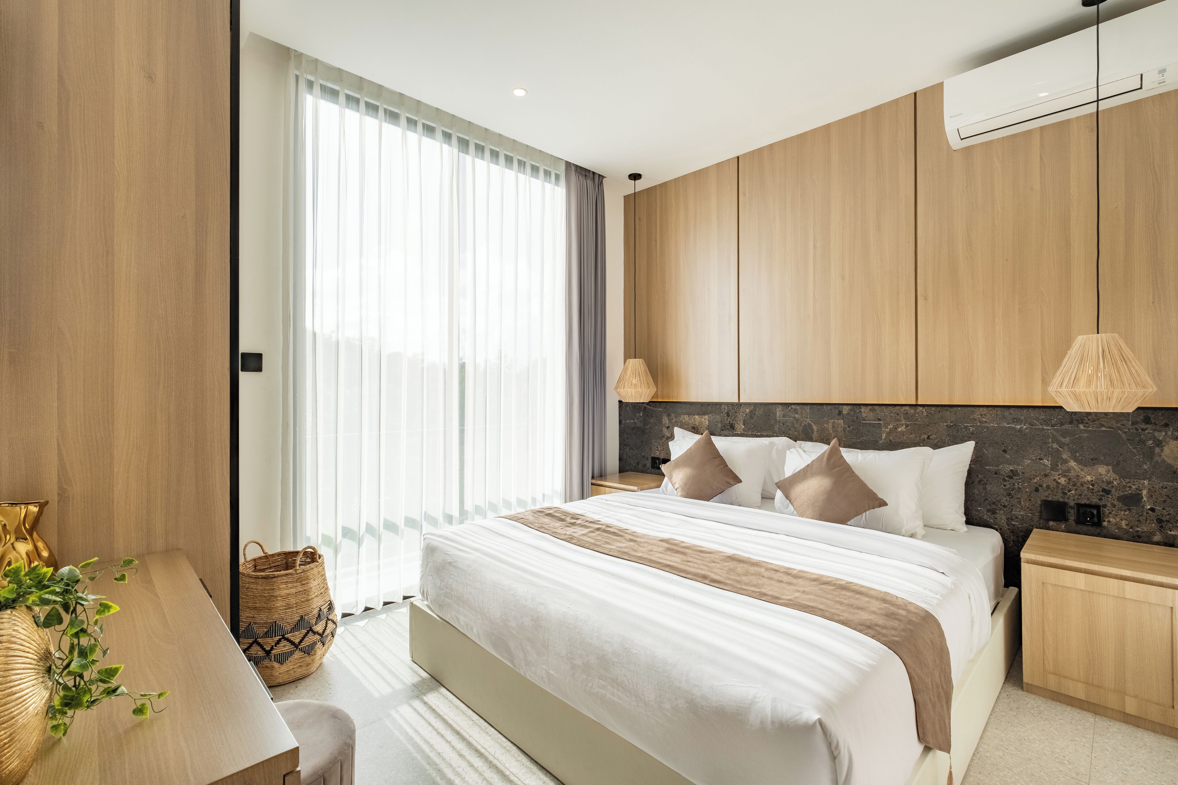 Un dormitorio moderno con una cama grande, paneles de madera y una pared de acento de piedra.