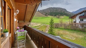 A wooden balcony with a view of a green valley and hills. - Apartment 'Place In The Bavarian Mountains' with Mountain View, Private Garden and Wi-Fi (Schneizlreuth)