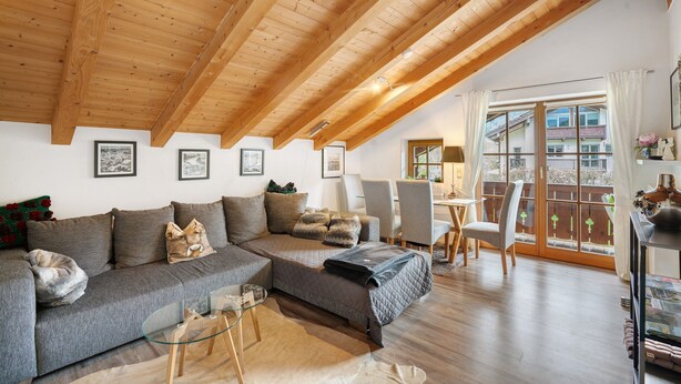 A cozy living room with a wooden ceiling, a grey sofa, a glass coffee table, and a balcony with a view. - Apartment 'Place In The Bavarian Mountains' with Mountain View, Private Garden and Wi-Fi (Schneizlreuth)