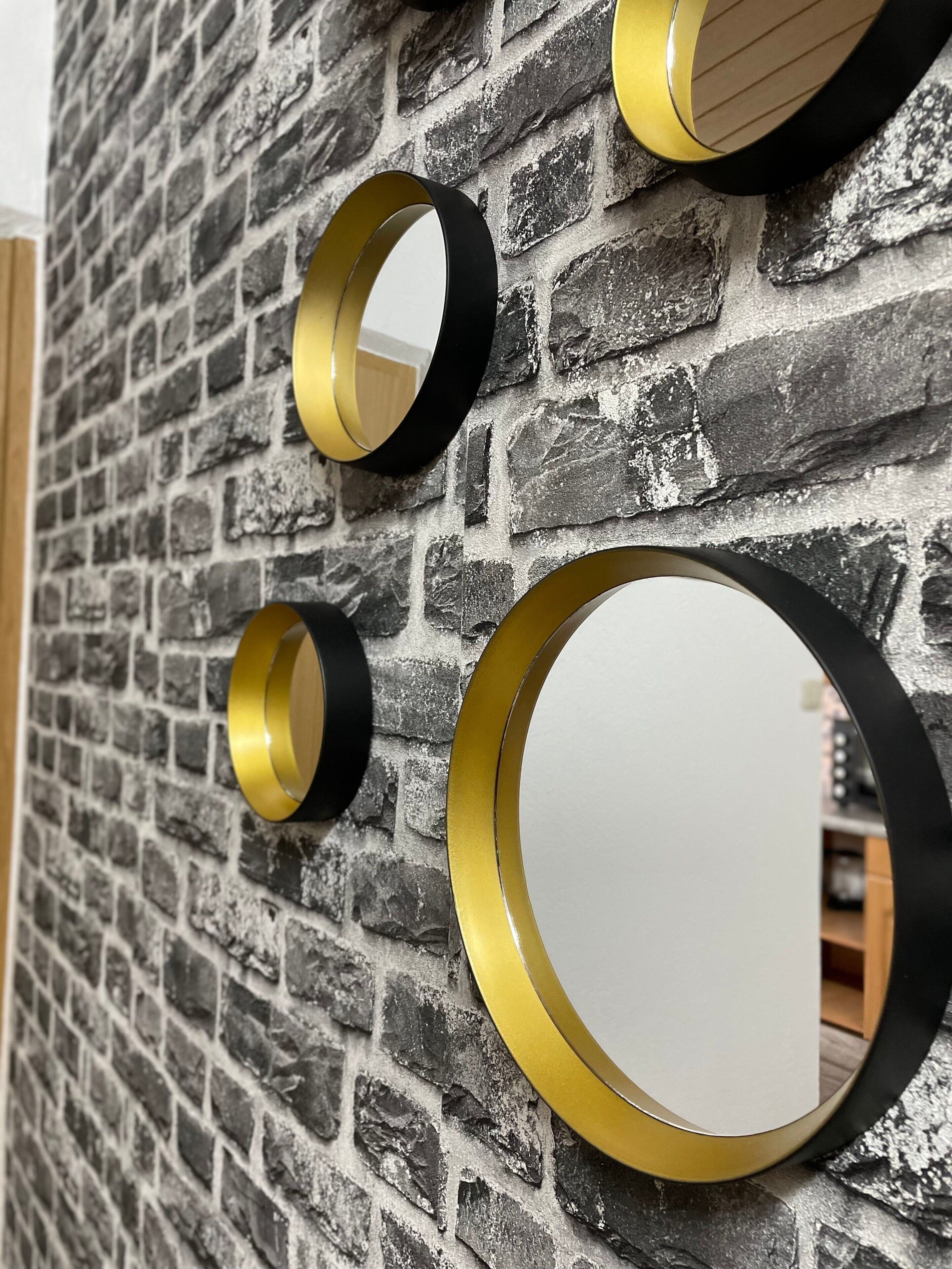 A wall with three circular mirrors of varying sizes.