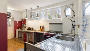 A kitchen with stainless steel appliances, a double sink, and pendant lighting. - Finca 'Gottsdorf' with Private Terrace and Shared Garden (Nuthe-Urstromtal)