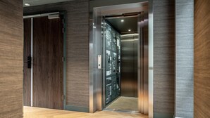 A modern elevator interior with a wooden floor and metallic walls. - Beautiful apartment, view of Delft canal. (Delft)