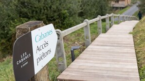 A wooden boardwalk leading to a building labeled "Cabanes Accès piétons." - Escape to Nature in Vencimont (Vencimont)