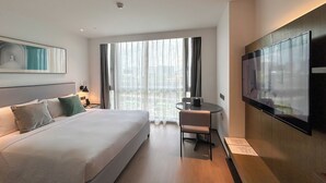 A hotel room with a large bed, a desk, a chair, a TV, and a window with curtains. - MCC Hotel Hangzhou Grand Canal (Hangzhou)
