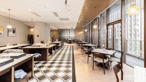 A modern dining area with tables, chairs, and large windows. - MCC Hotel Hangzhou Grand Canal (Hangzhou)