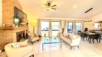 Cozy living space with a fireplace, comfortable seating, and a dining area offering a view.