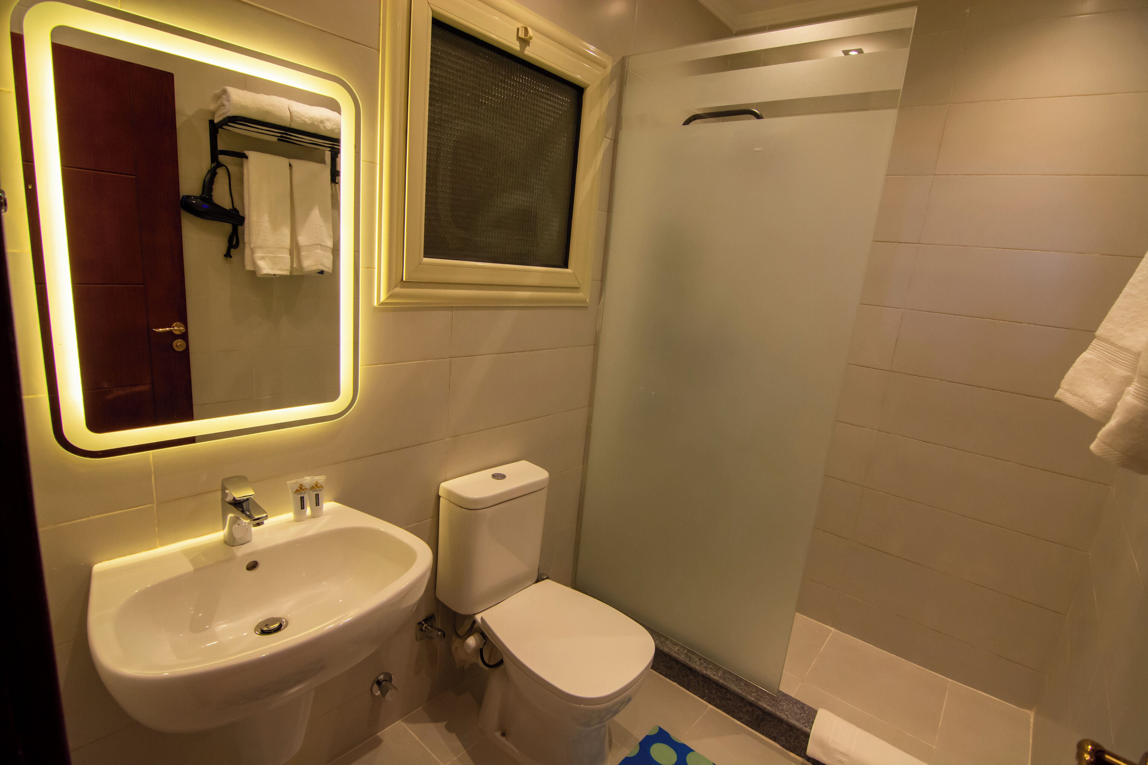 A bathroom with a sink, toilet, and shower.