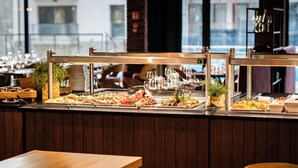 A buffet setup with various food items and a wine glass display.