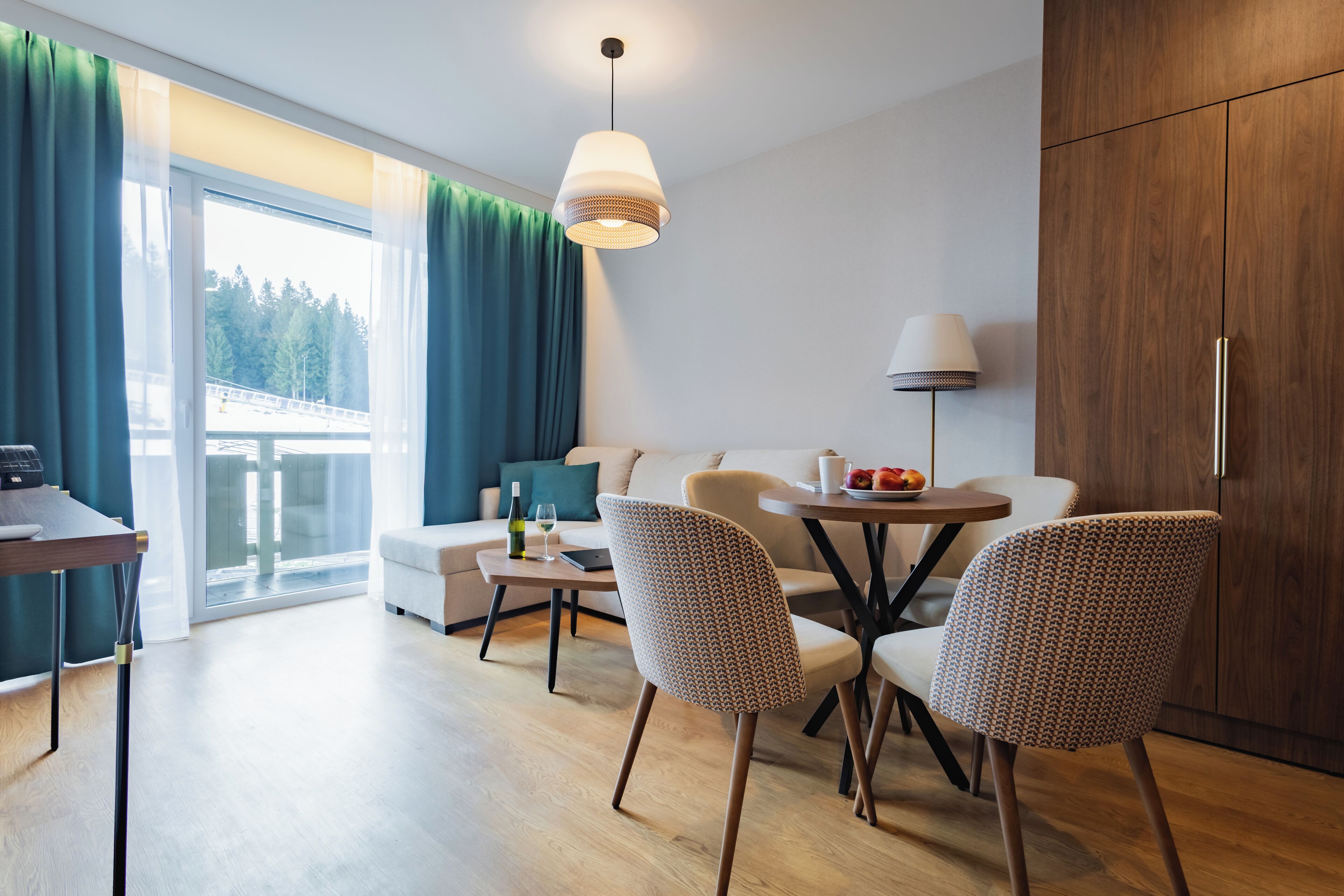 Ein modernes Wohnzimmer mit einer Couch, Sesseln, einem Esstisch und einer Lampe.
