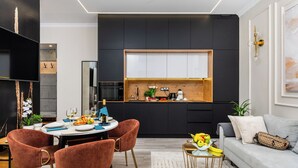 Eine moderne Küche mit einer zentralen Kochinsel, dunklen Schränken und einer Holz Arbeitsplatte.