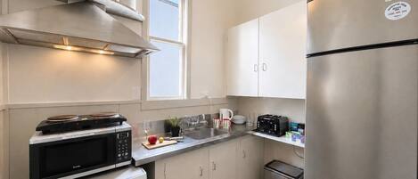 A modern kitchen with stainless steel appliances, a microwave, a toaster, and a refrigerator.