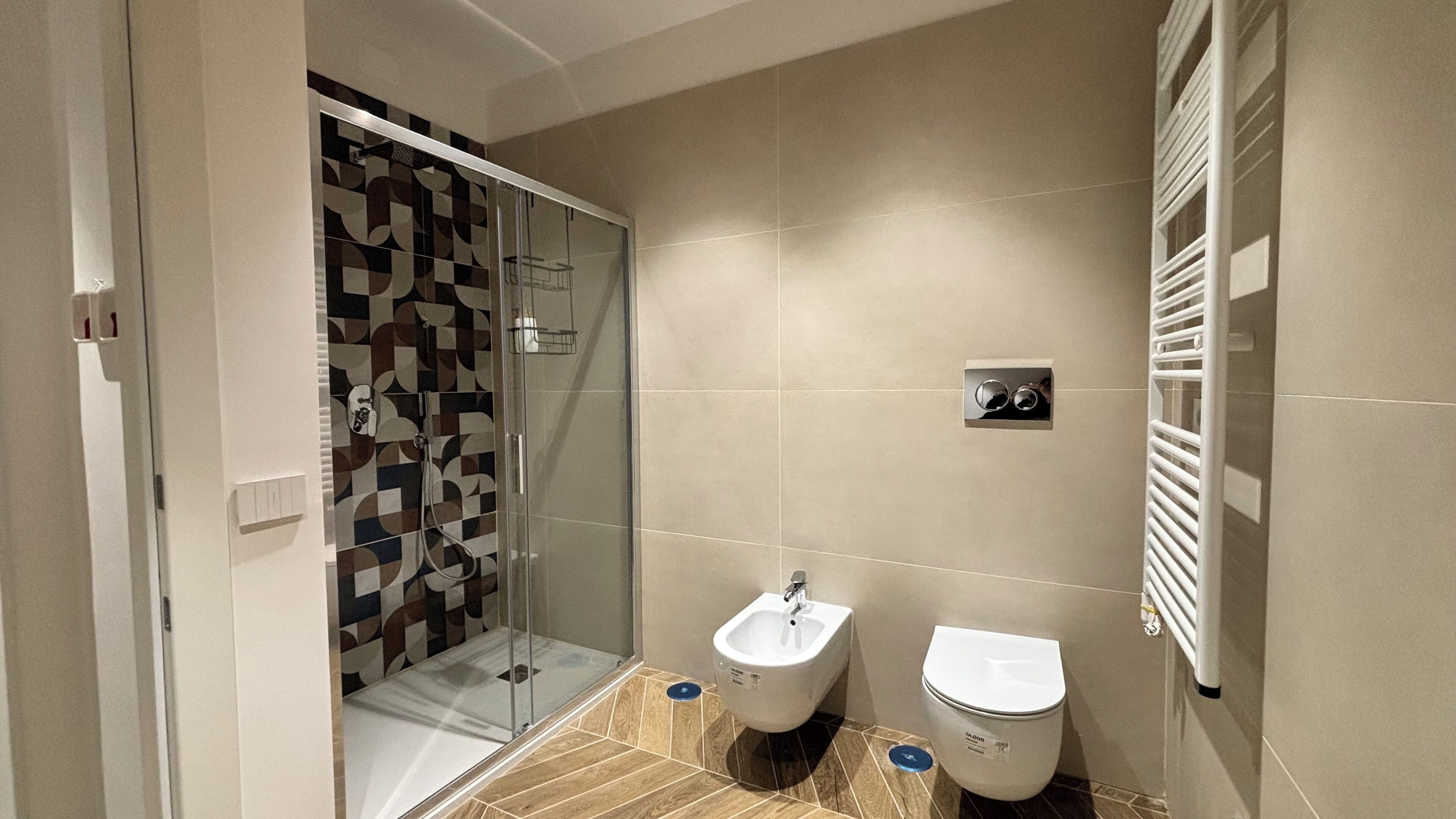 Un bagno moderno con box doccia in vetro, un bidet e un water.