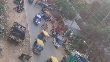 Escena de calle concurrida, con varios rickshaws, motocicletas y peatones.