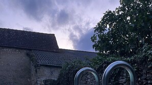 A swimming pool with metal ladders, surrounded by stone walls and a wooden deck. - Elegant, charming residence with landscaped garden (Jazennes)