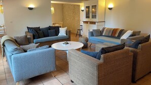 A living room with a sectional sofa, a round coffee table, and wicker furniture. - Elegant, charming residence with landscaped garden (Jazennes)
