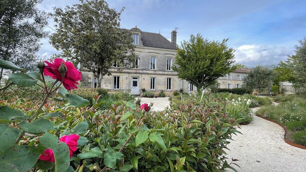 A historic stone building with a symmetrical facade, a gravel pathway, and lush greenery. - Elegant, charming residence with landscaped garden (Jazennes)