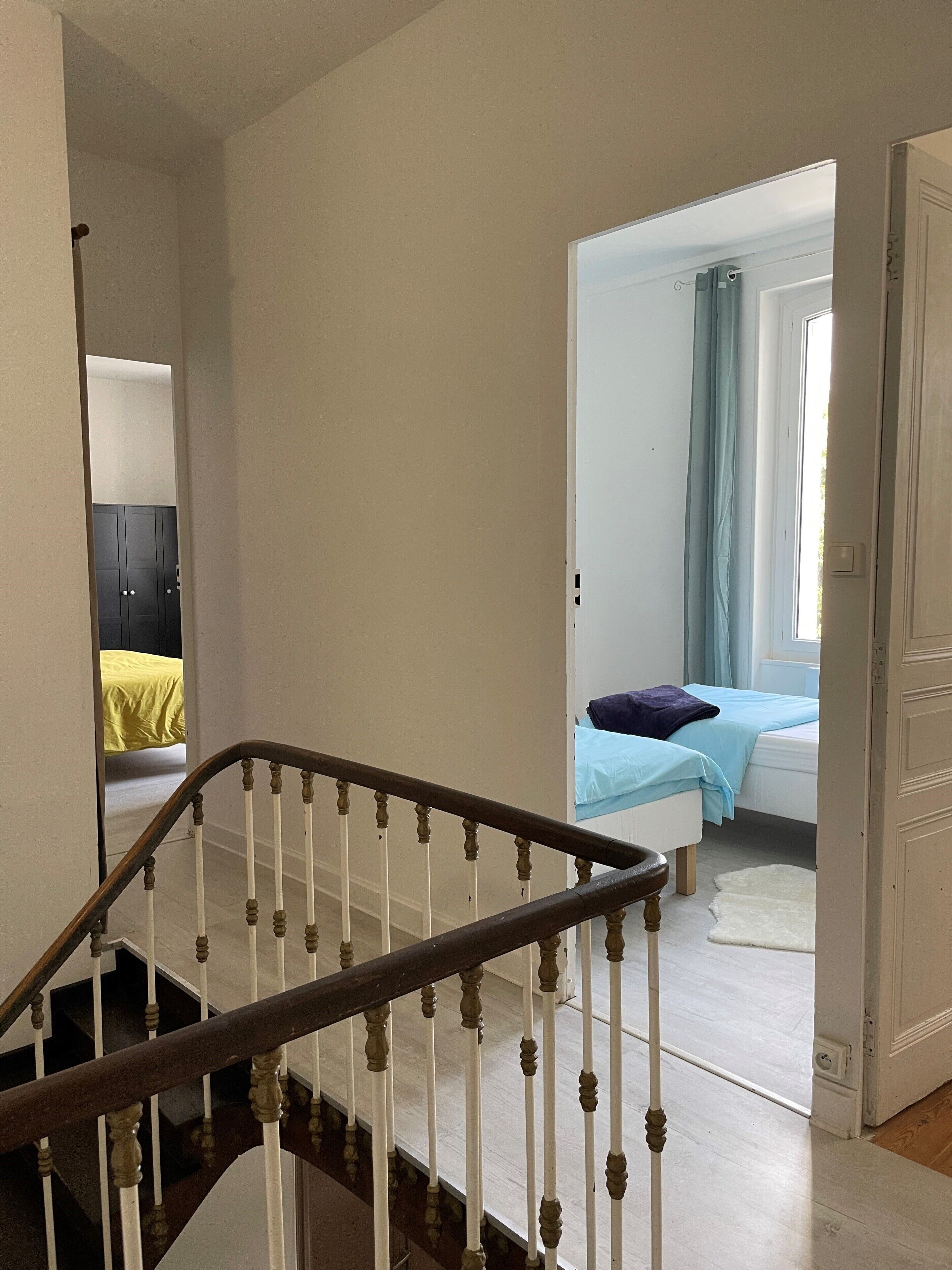 A staircase leading to a bedroom with a bed and a window.