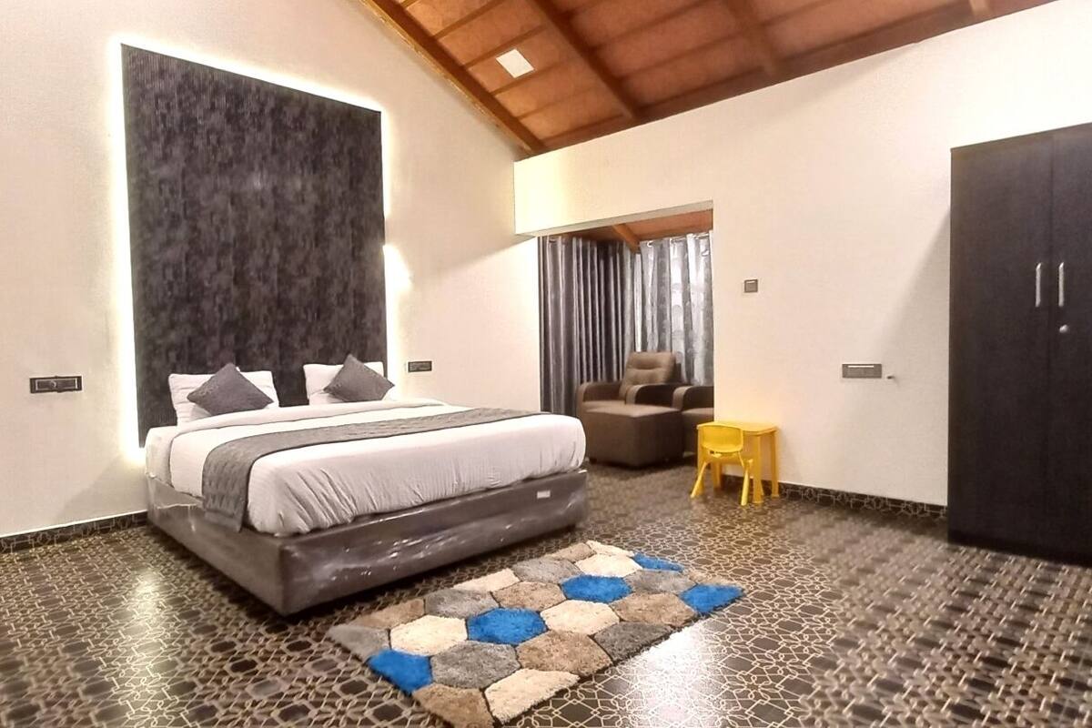 A bedroom with a bed, a wardrobe, a small table, and a chair.