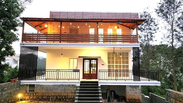 A modern two-story house with a balcony, a front door, and a stone pathway leading to the entrance. - Orion Blu Yercuad (Yercaud)