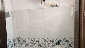 A bathroom with a toilet, a water heater, and a shower. - Hotel Golden Arch  (Bangalore)