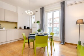 Enjoy a compact living space with a dining area, kitchen, and large window offering a view of the outside balcony.
