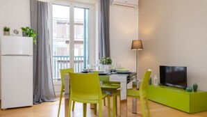 Un salon moderne comprenant un coin repas, un téléviseur à écran plat et un balcon avec vue.
