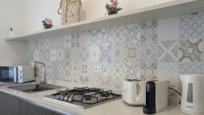 Una cocina moderna con estufa a gas, tostadora, cafetera y hervidor.